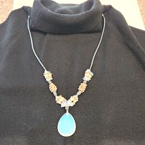 Beautiful artisan Shell and beaded necklace.  The large stone medallion glows.